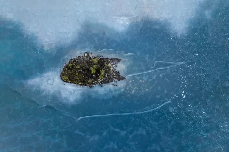 Aerial view of a small island surrounded by cracked sea ice in Norway