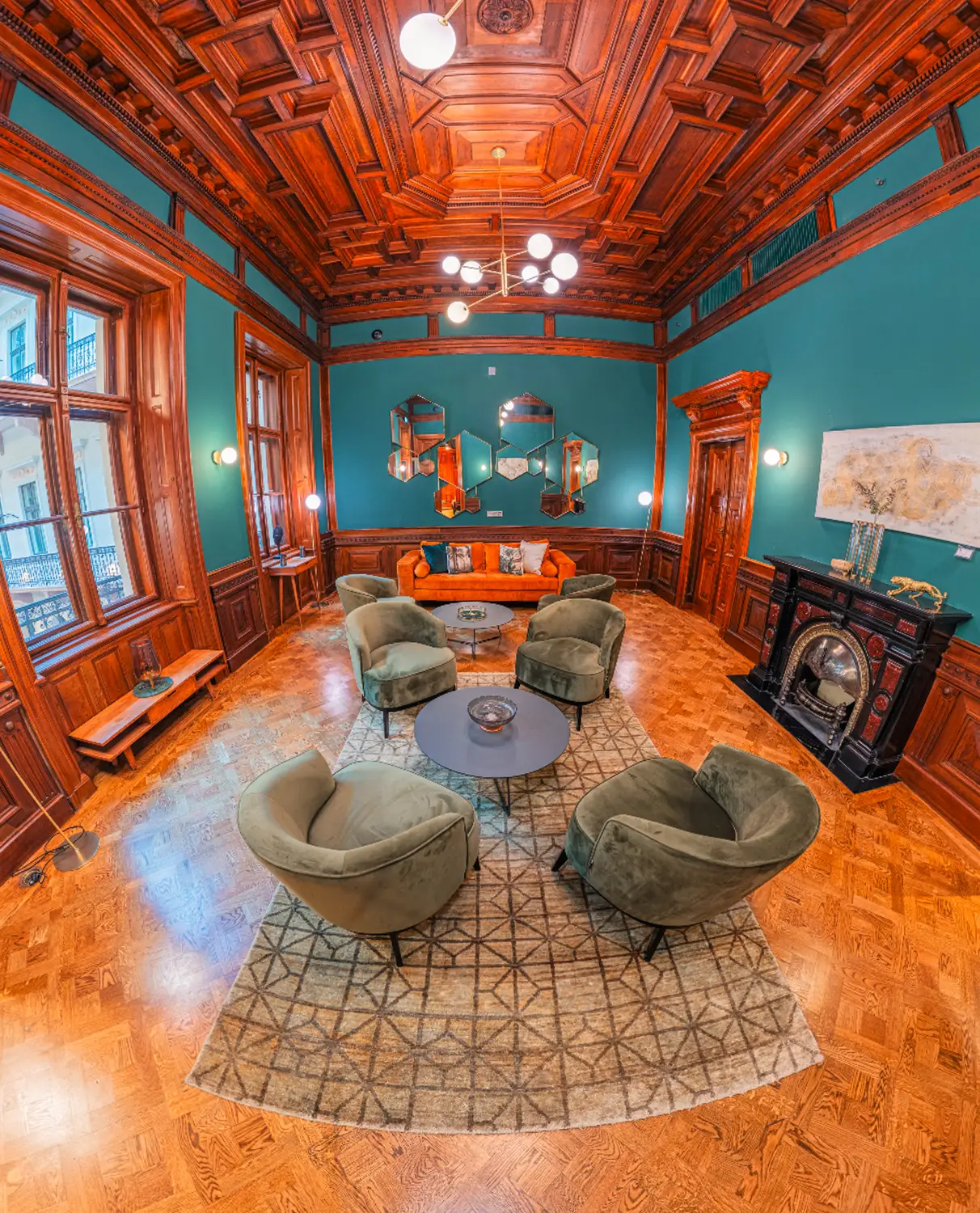 Snapshot from a virtual tour of an elegant hotel interior with carved wood panelling, fireplace, and period furniture.