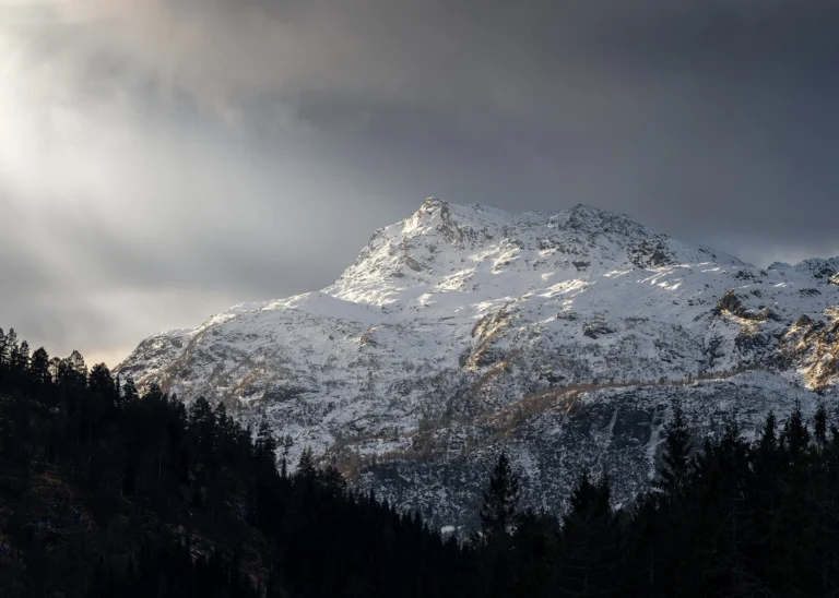 Snow-covered Norwegian mountain ridge rising into a soft pale winter sky